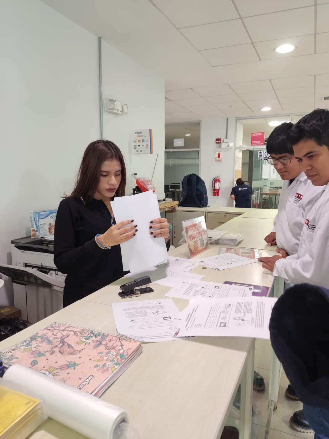 Colaboradora organizando documentos para estudiantes